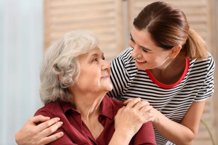 Elderly woman with female caregiver at home.