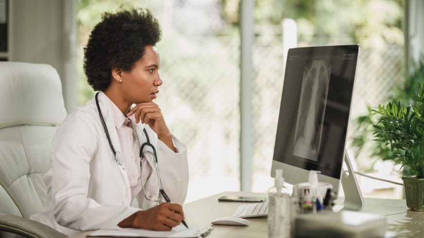 Doctor examining lung x-ray results on computer screen.