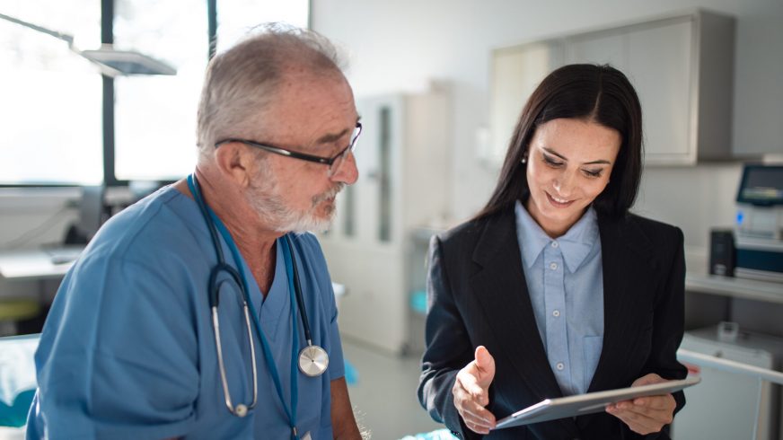 Young pharmaceutic seller explaining something to doctor in hospital.